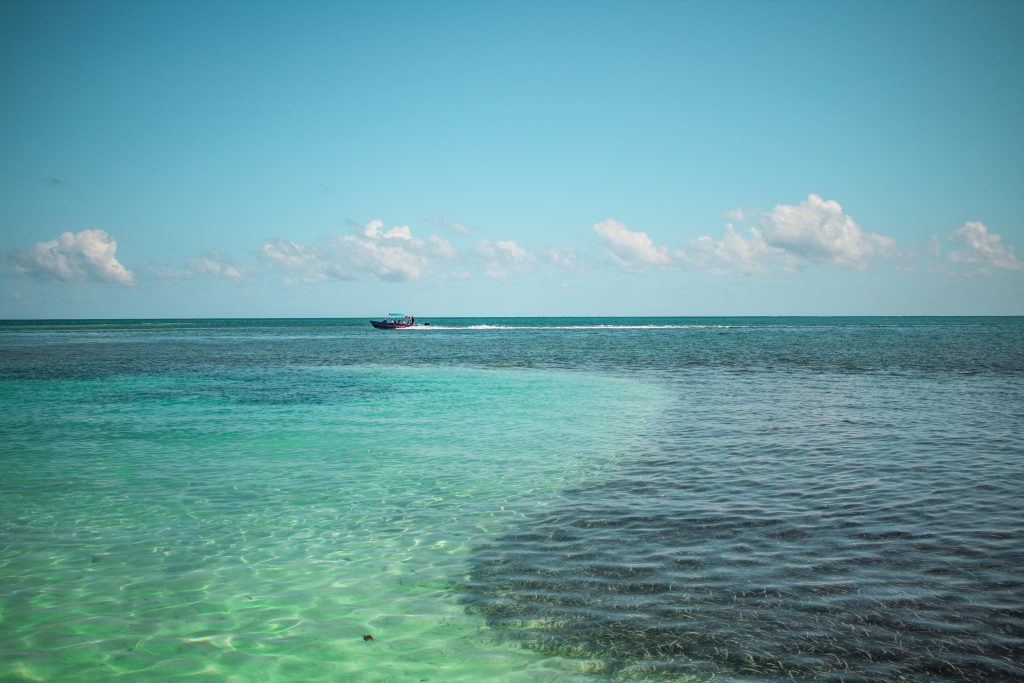 Teal blue water with a boat in the distance in Florida
