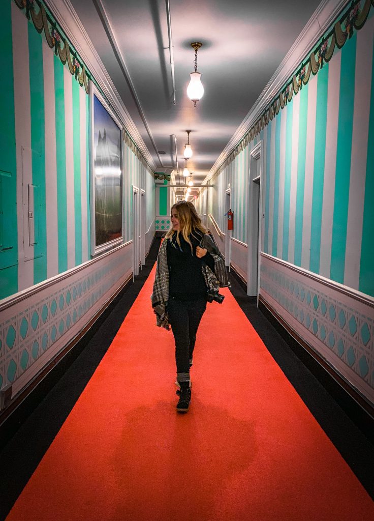 Me walking through the blue and white-walled hallways